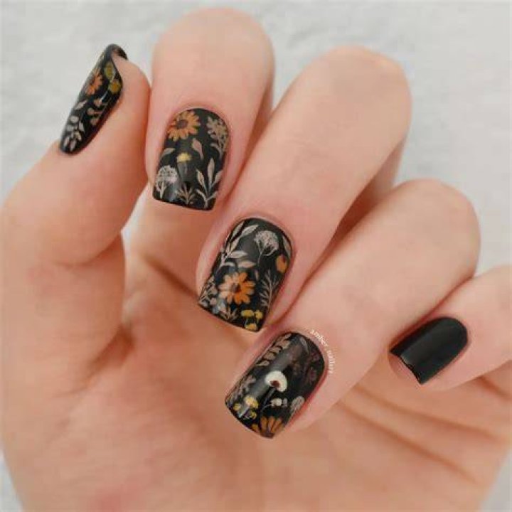 Dark moody floral nail art with deep burgundy roses and emerald leaves