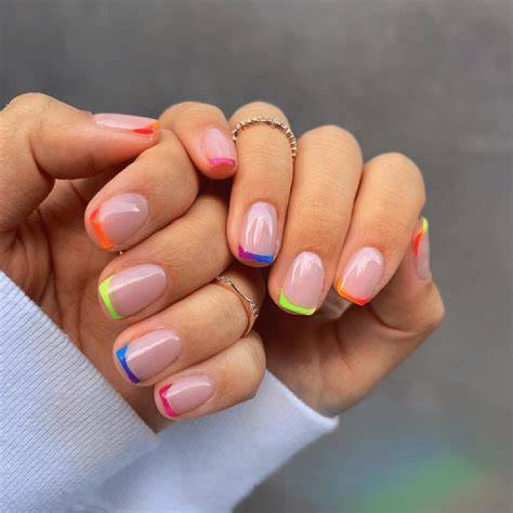 Reinvented French manicure with colored tips in lavender, sage, and caramel tones